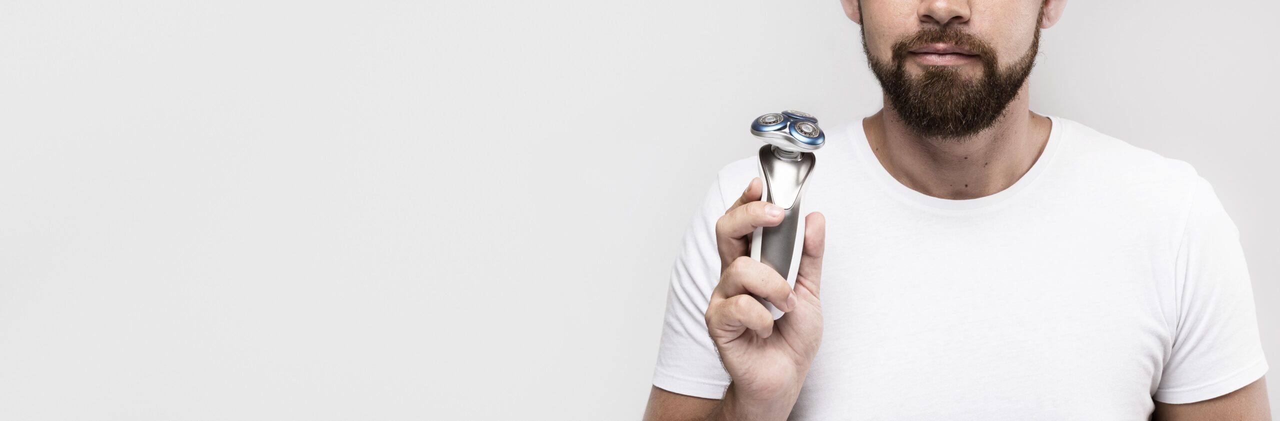 man-holding-electric-shaver-with-copy-space man-holding-electric-shaver-with-copy-space