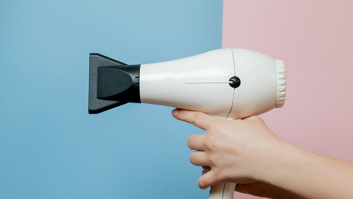 oman-hands-with-hair-dryer-blue-pink-background-beauty-con